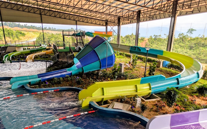 Water slides in the Splash Zone play area with lush greenery in the background.