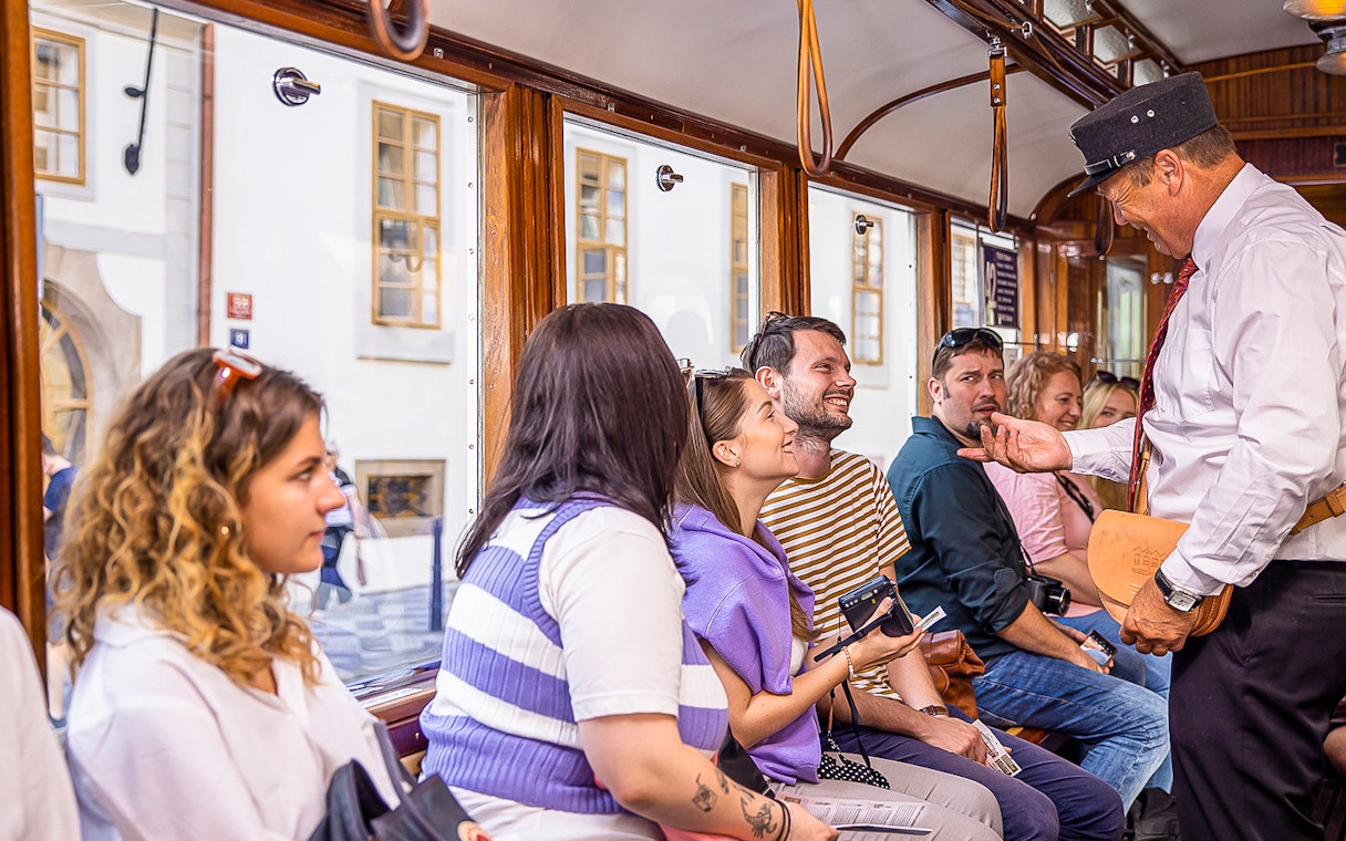 Tourists enjoying a guided tram tour in Prague.