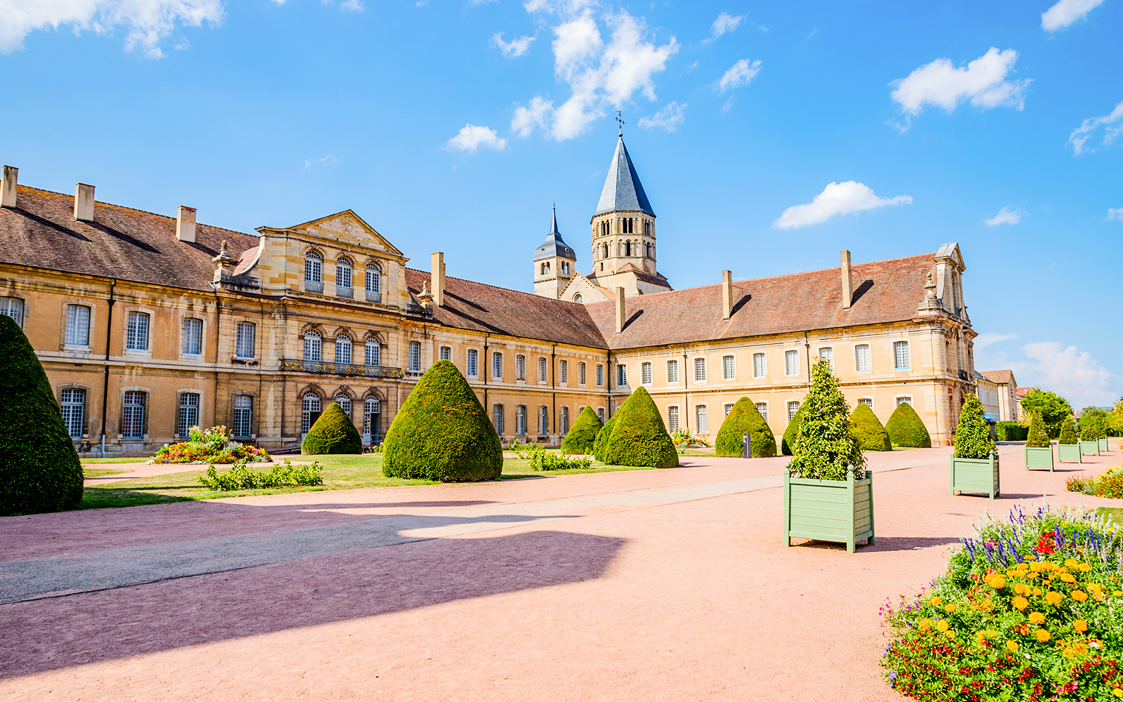 Abbaye de Cluny courtyard with manicured hedges and historic architecture, Lyon, France.