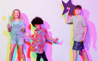 Kids interacting with colorful shadows at SparkLab, Queensland Museum.