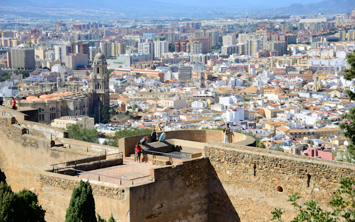 Tourists enjoying city view from Gibralfaro Castle in Málaga, Spain.