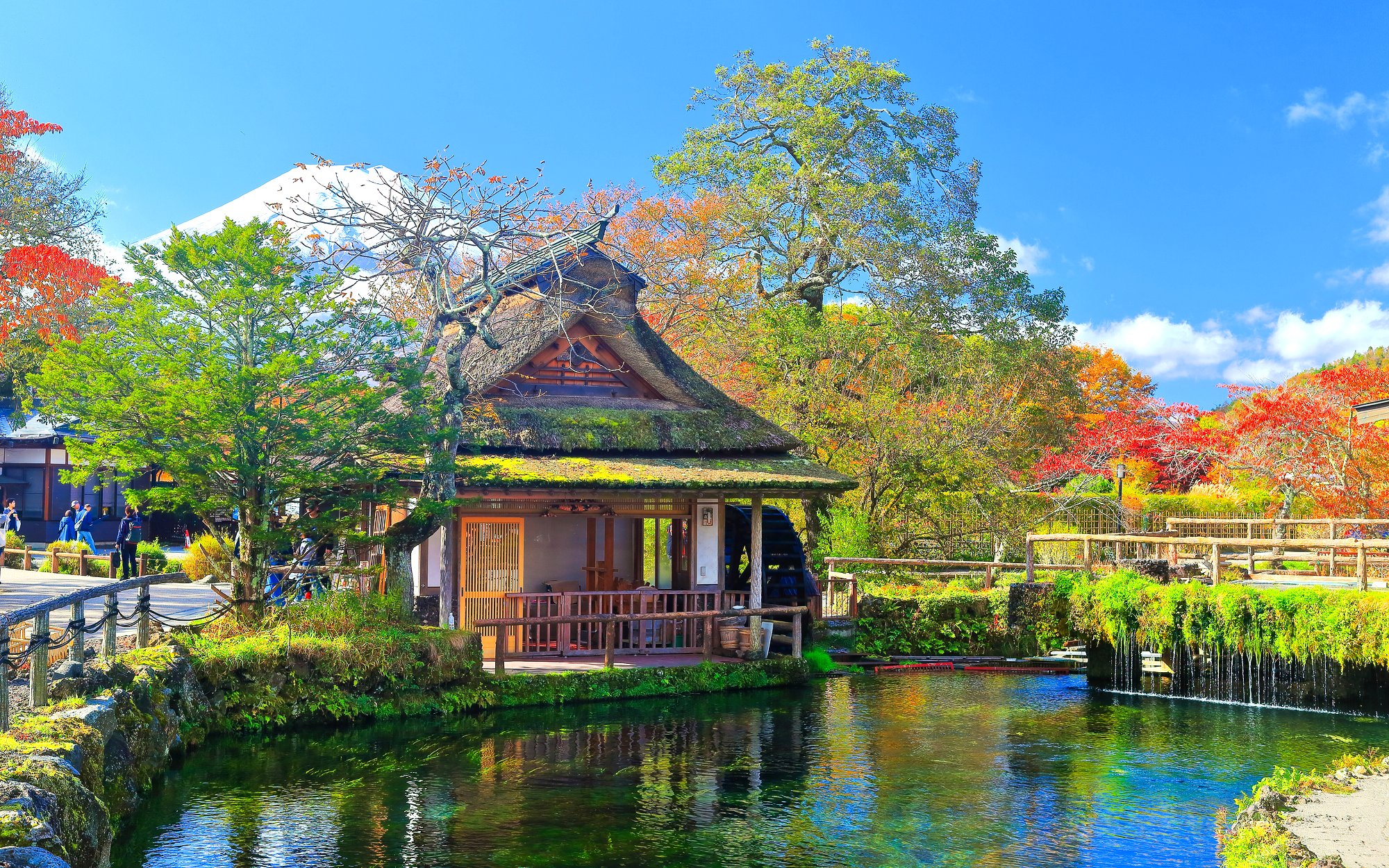 Traditional Japanese house by a pond with Mt. Fuji in the background, Lake Kawaguchiko area.