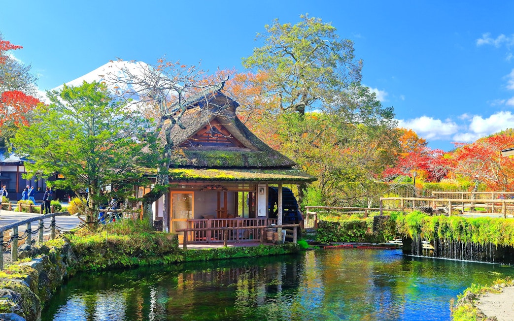Traditional Japanese house by a pond with Mt. Fuji in the background, Lake Kawaguchiko area.