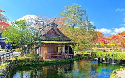 Traditional Japanese house by a pond with Mt. Fuji in the background, Lake Kawaguchiko area.