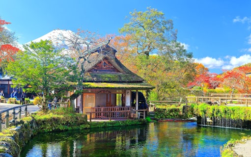 Traditional Japanese house by a pond with Mt. Fuji in the background, Lake Kawaguchiko area.