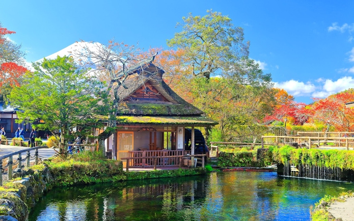 Traditional Japanese house by a pond with Mt. Fuji in the background, Lake Kawaguchiko area.
