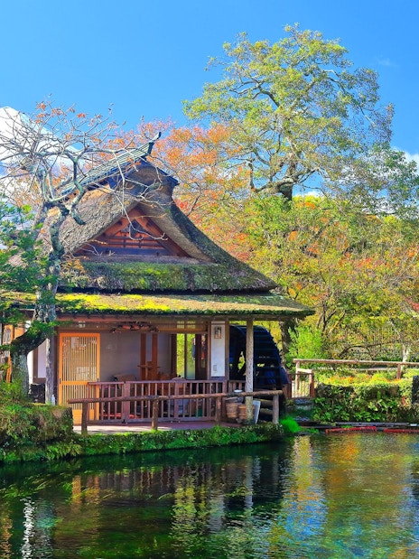 Traditional Japanese house by a pond with Mt. Fuji in the background, Lake Kawaguchiko area.