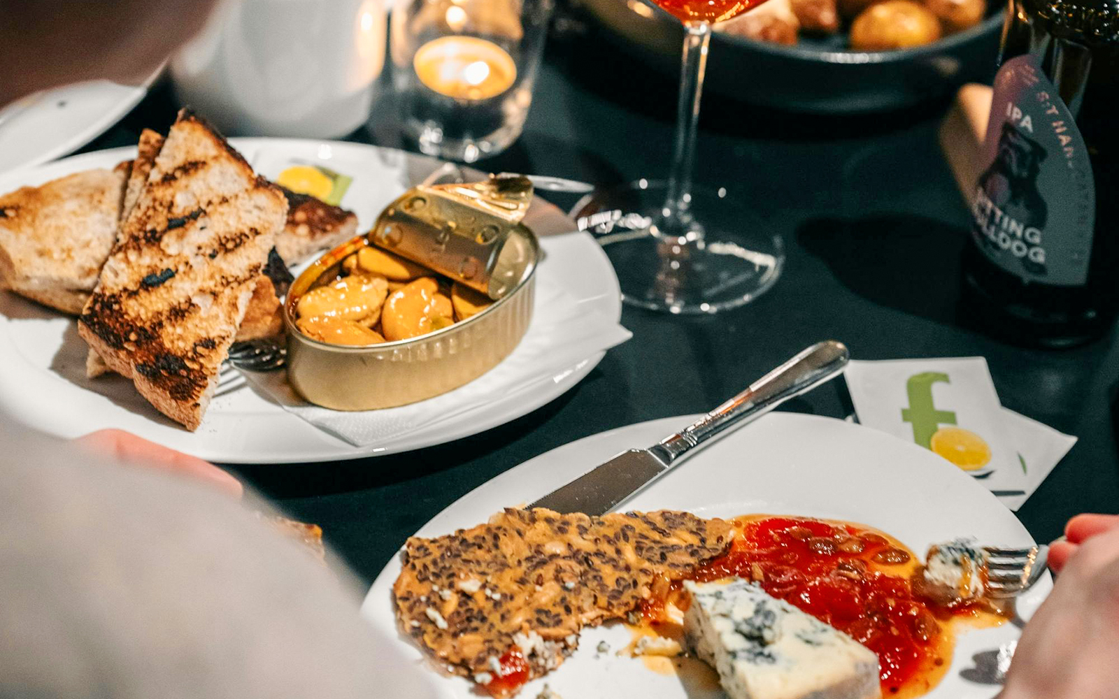 Dining experience at Nobel Prize Museum with cheese, crackers, and canned seafood.