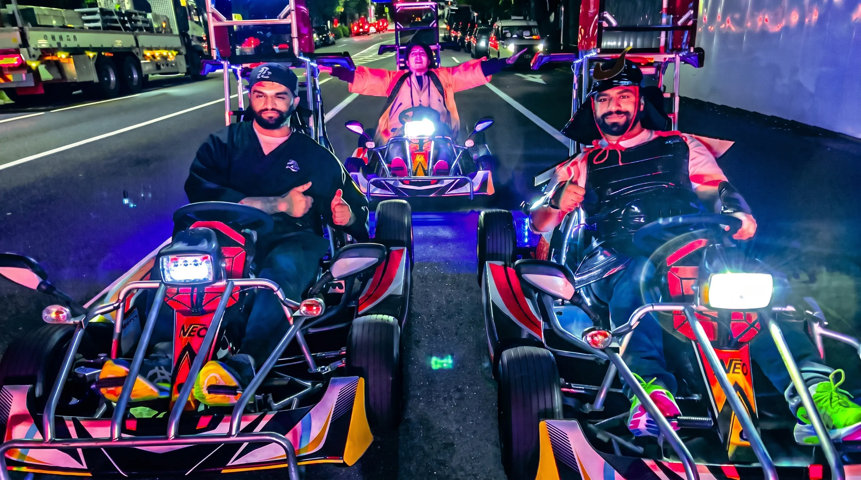 People driving go-karts on a street in Ginza at night.