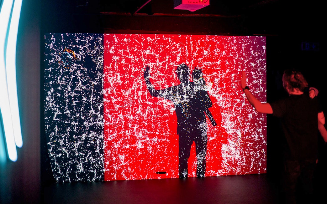 Visitor interacting with digital light display at Lumia Gallery exhibition.