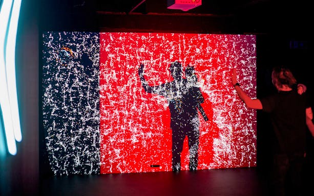 Visitor interacting with digital light display at Lumia Gallery exhibition.
