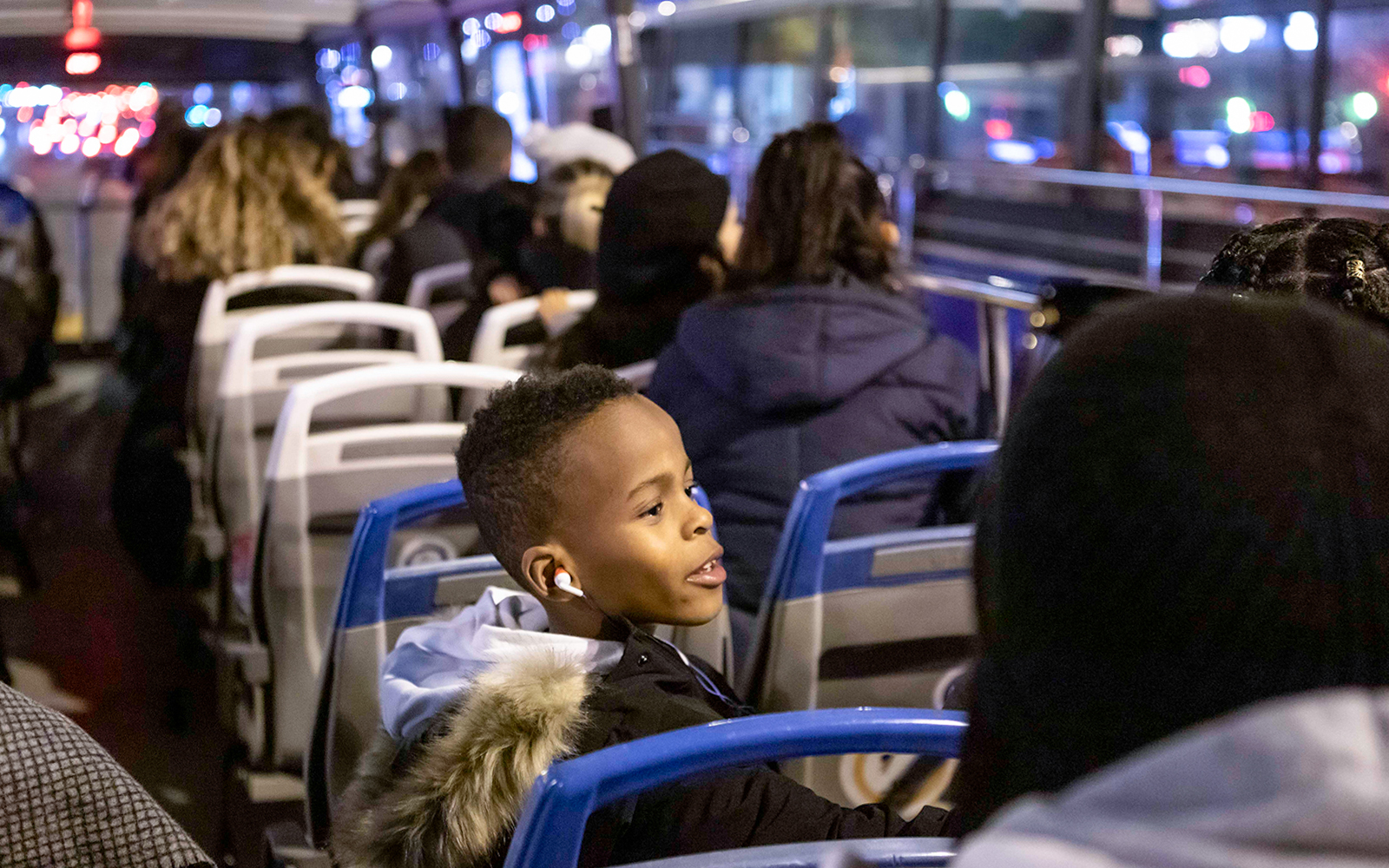 Bus passengers enjoying a Christmas lights tour at night.