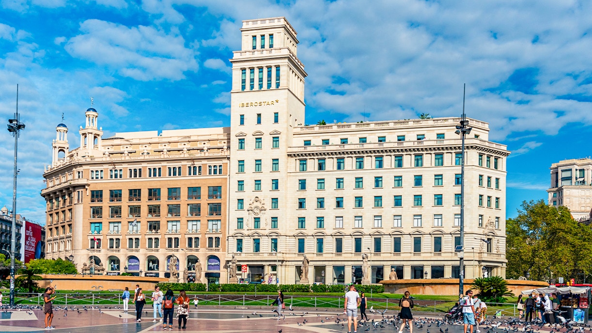 Placa de Catalunya Barcelona bustling square with people and pigeons.
