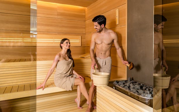 Couple enjoying sauna at Therme Erding spa area.