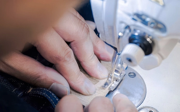 Sewing denim jeans with a machine at Harajuku, Tokyo Denim Jeans Making Experience.
