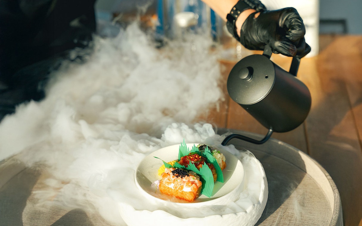 Gourmet dish with smoke effect on Sunseeker Superyacht dining experience.