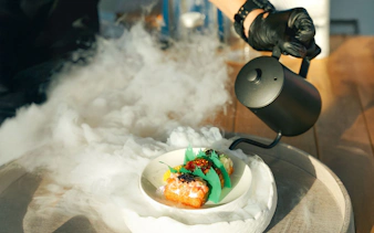Gourmet dish with smoke effect on Sunseeker Superyacht dining experience.