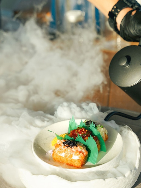 Gourmet dish with smoke effect on Sunseeker Superyacht dining experience.