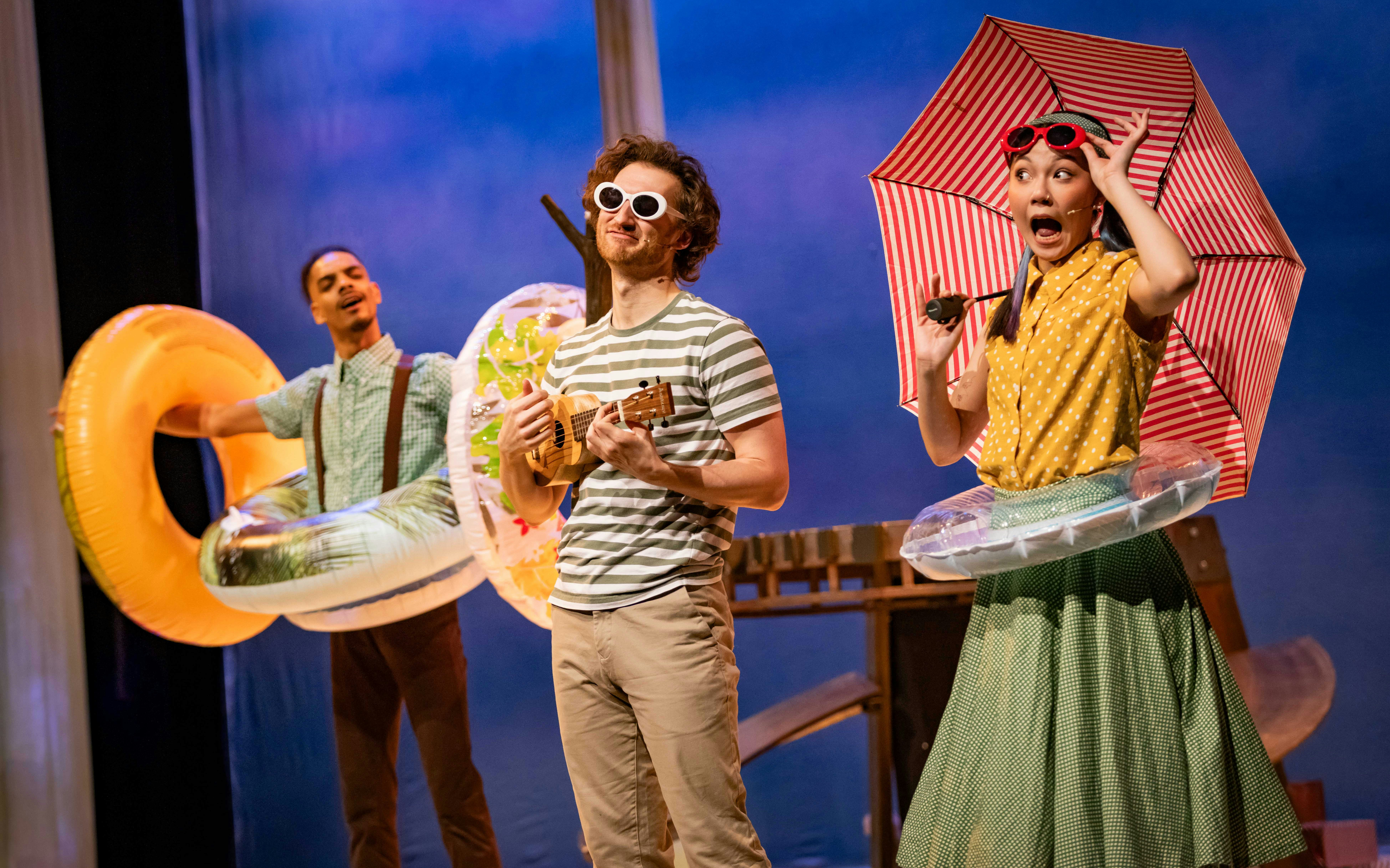 Stage performance of Stick Man in Westend with actors in summer attire and props.