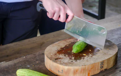 Chopping cucumber during meal preparation at Krabi Roaming Elephant Sanctuary.