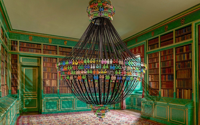Chandelier in the library of Liria Palace, Madrid, surrounded by bookshelves.