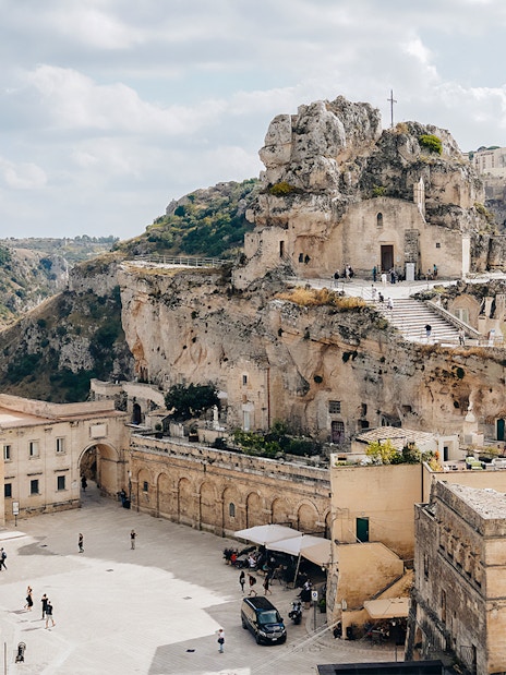 Matera's ancient stone buildings and rock church on a guided tour.
