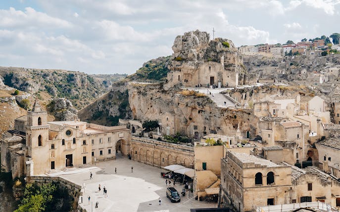 Matera's ancient stone buildings and rock church on a guided tour.