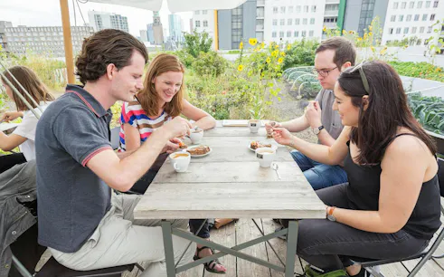 Group enjoying food and drinks at an outdoor table during Rotterdam Walking Food Tour.