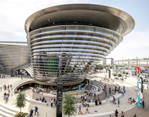 Aerial view of Expo City Dubai entrance with futuristic architecture and surrounding landscape.