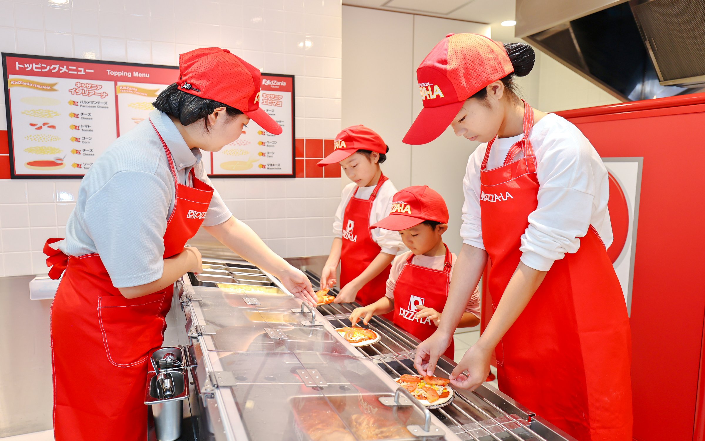 Children making pizzas at KidZania Fukuoka pizzeria.