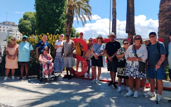 Group of tourists posing by a large red "S" sculpture during Split City Tour, Croatia.