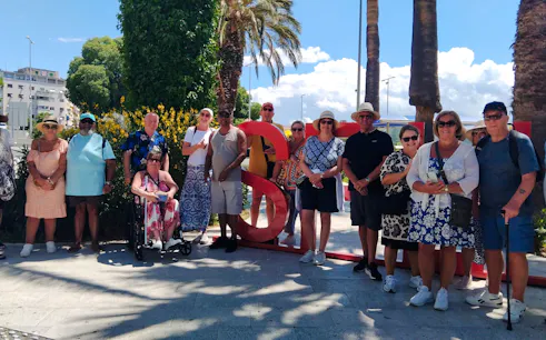 Group of tourists posing by a large red "S" sculpture during Split City Tour, Croatia.