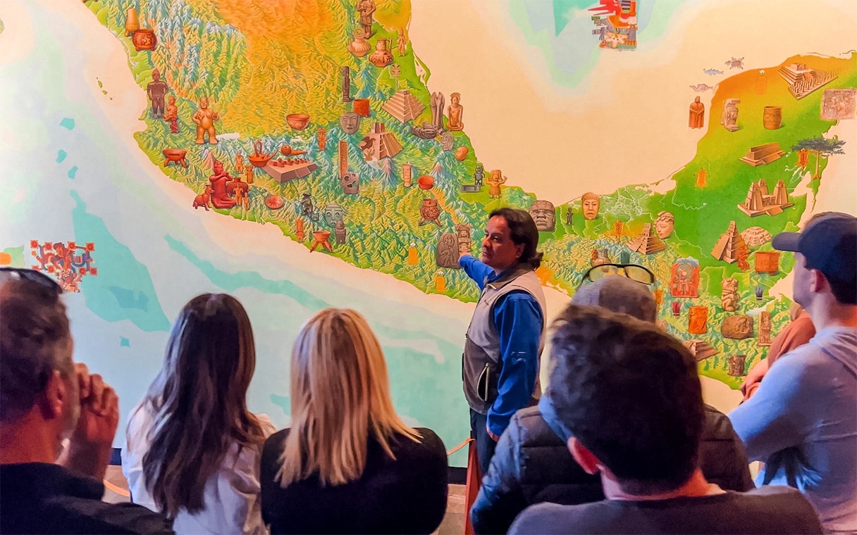 Visitors listening to a guide at the National Museum of Anthropology, Mexico City.
