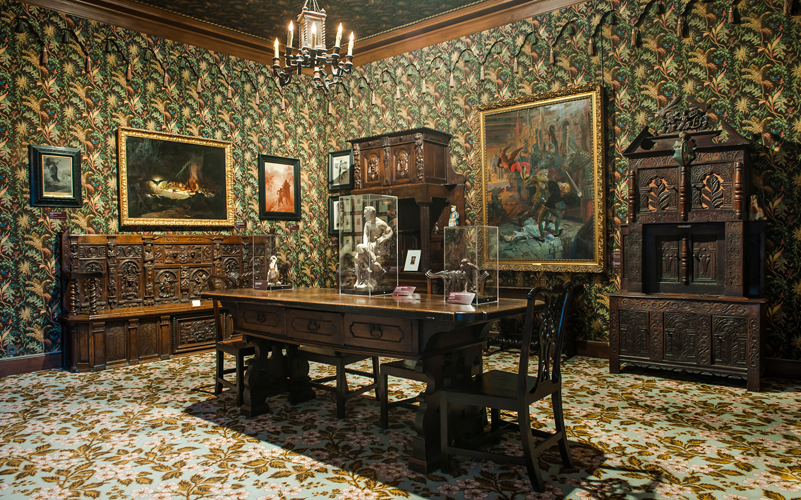 Interior of The Victor Hugo House in Paris, featuring ornate wooden furniture and framed artwork.