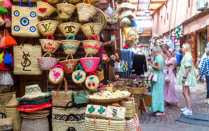 Woven baskets and tourists in Marrakech souk during guided tour.