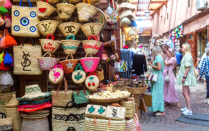Woven baskets and tourists in Marrakech souk during guided tour.