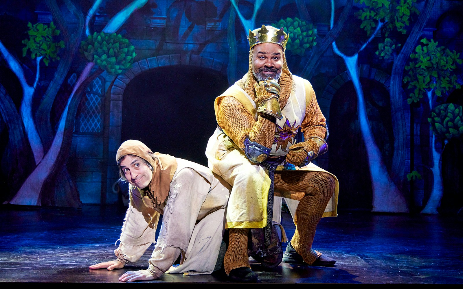 Stage scene from Spamalot with actors in medieval costumes.
