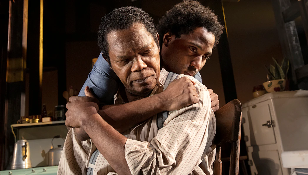 Two actors embrace in a scene from "The Piano Lesson" play.