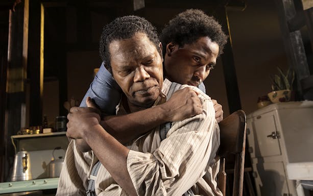 Two actors embrace in a scene from "The Piano Lesson" play.