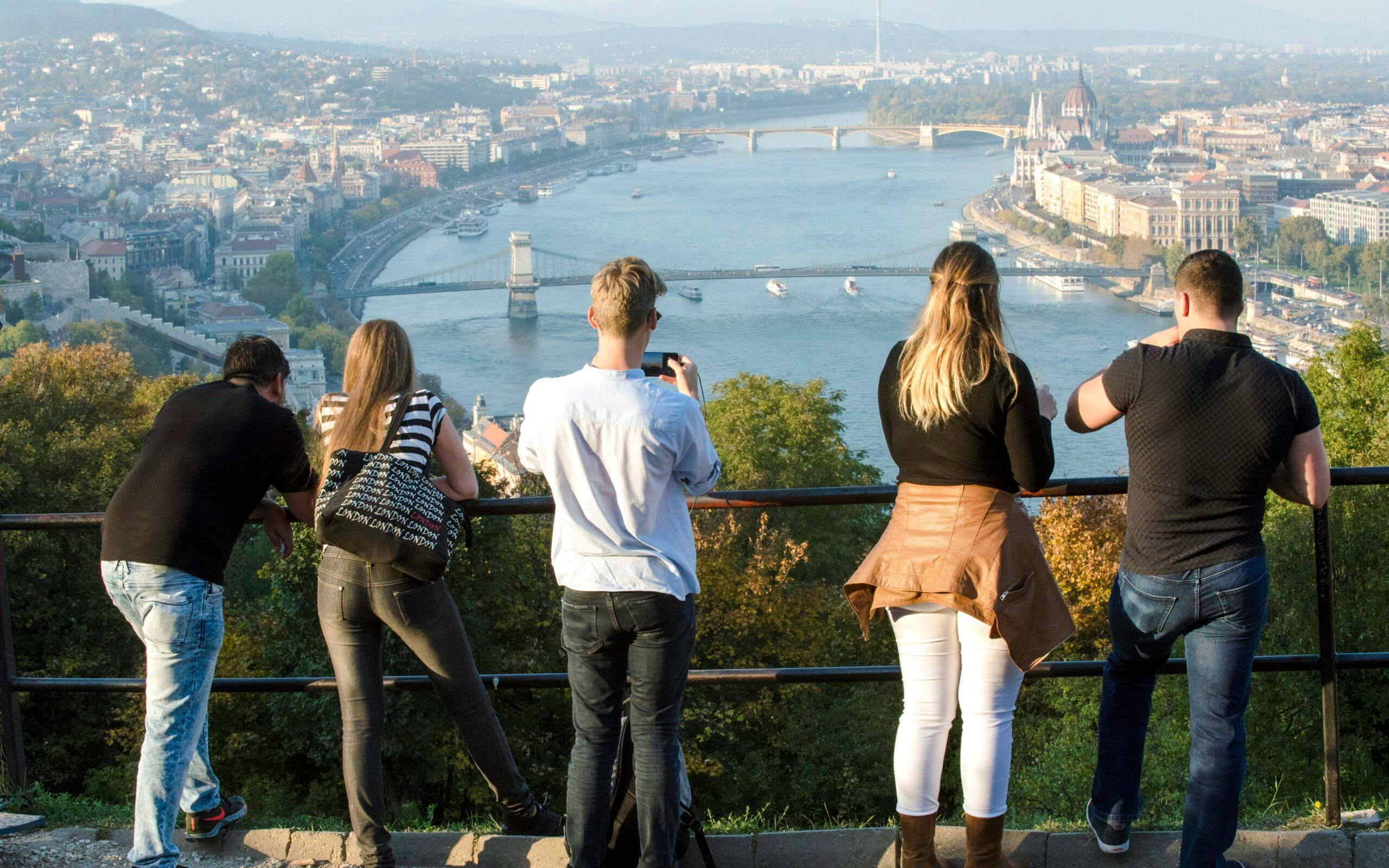 Tourists overlooking the Danube River and Chain Bridge in Budapest.