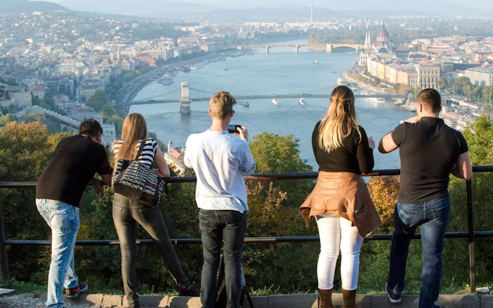 Tourists overlooking the Danube River and Chain Bridge in Budapest.
