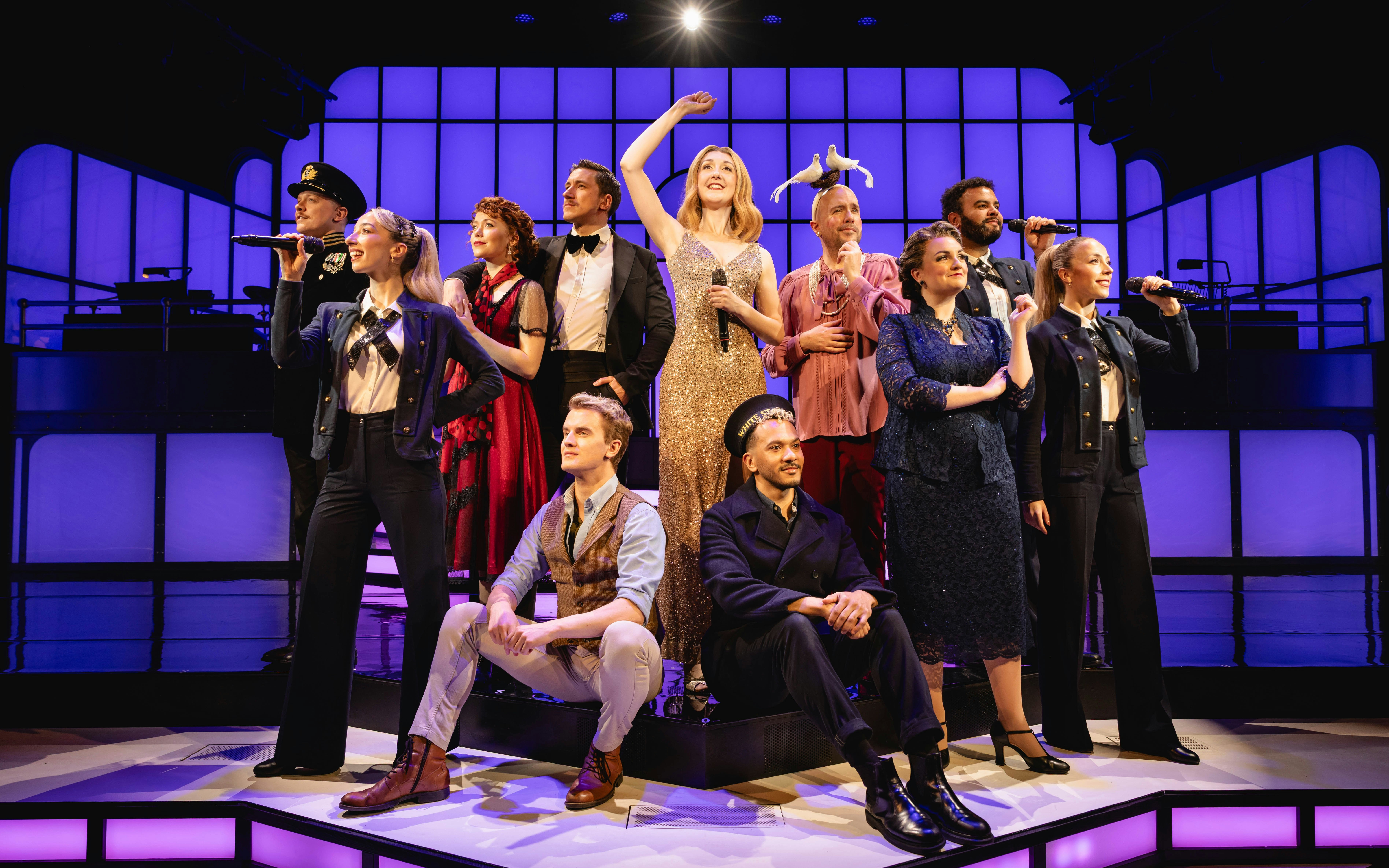 Cast performing Titanique on West End stage with vibrant lighting.