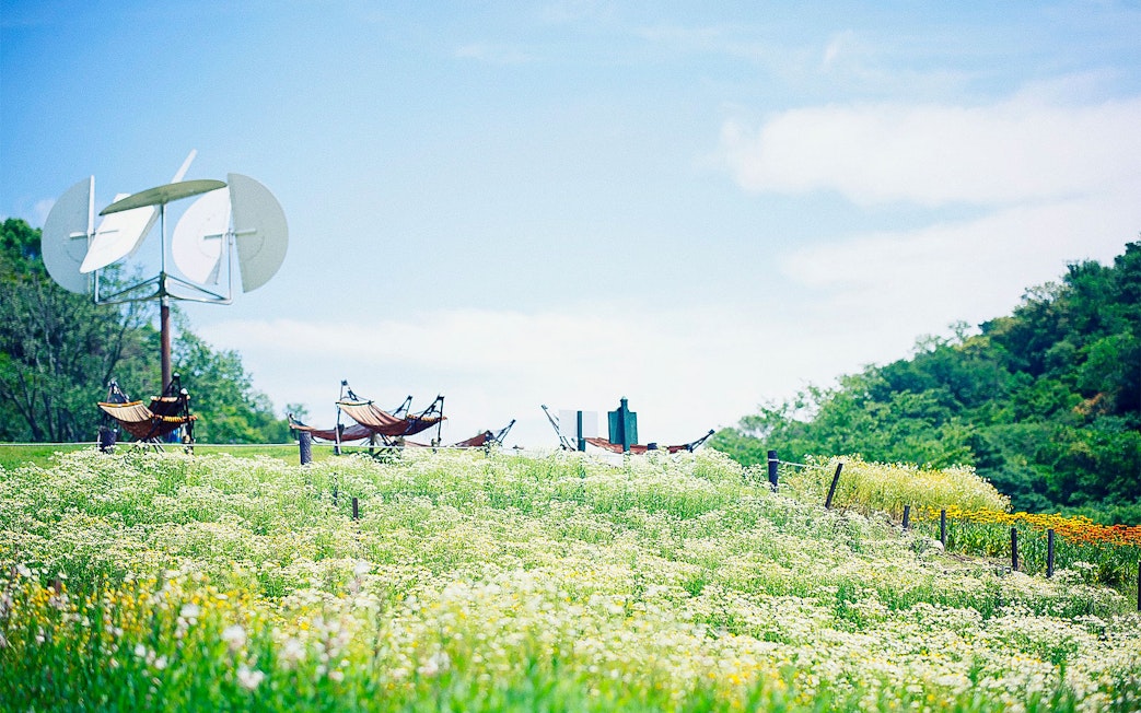 Kobe Nunobiki Herb Gardens with hammocks and windmill under clear sky.