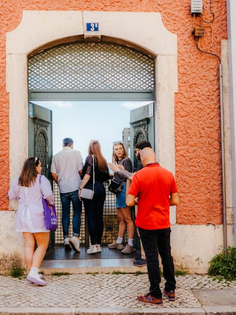 Visitors entering SE Cathedral in Lisbon through an ornate doorway.