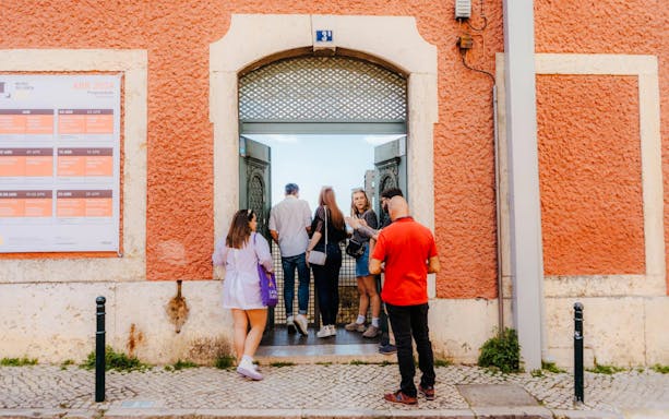 Visitors entering SE Cathedral in Lisbon through an ornate doorway.