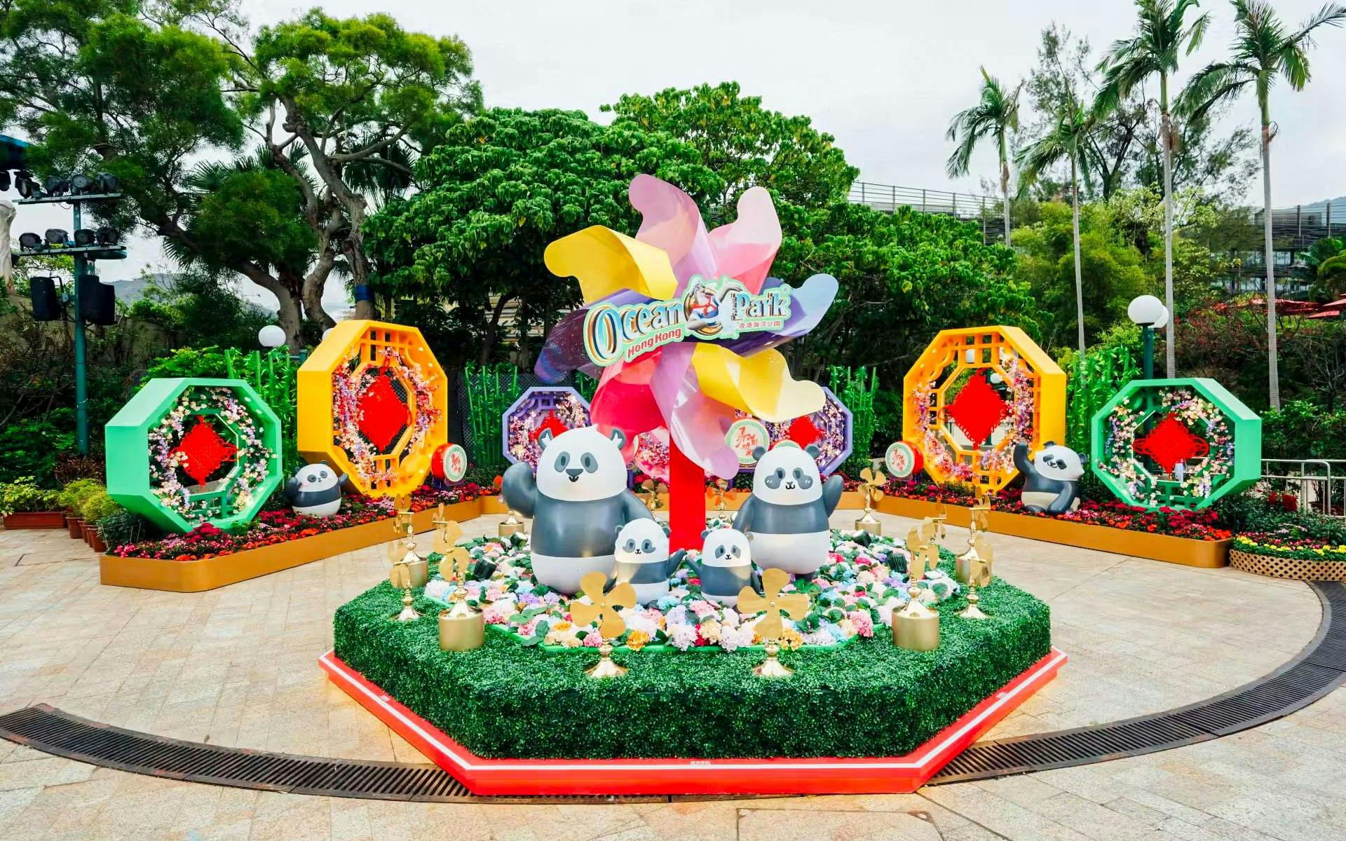 Giant panda figurines at Ocean Park Hong Kong surrounded by colorful decorations.