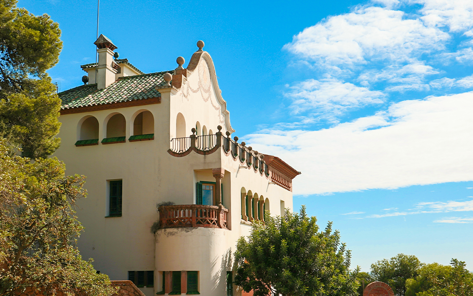 Casa Trías with arched windows and green shutters under a blue sky.