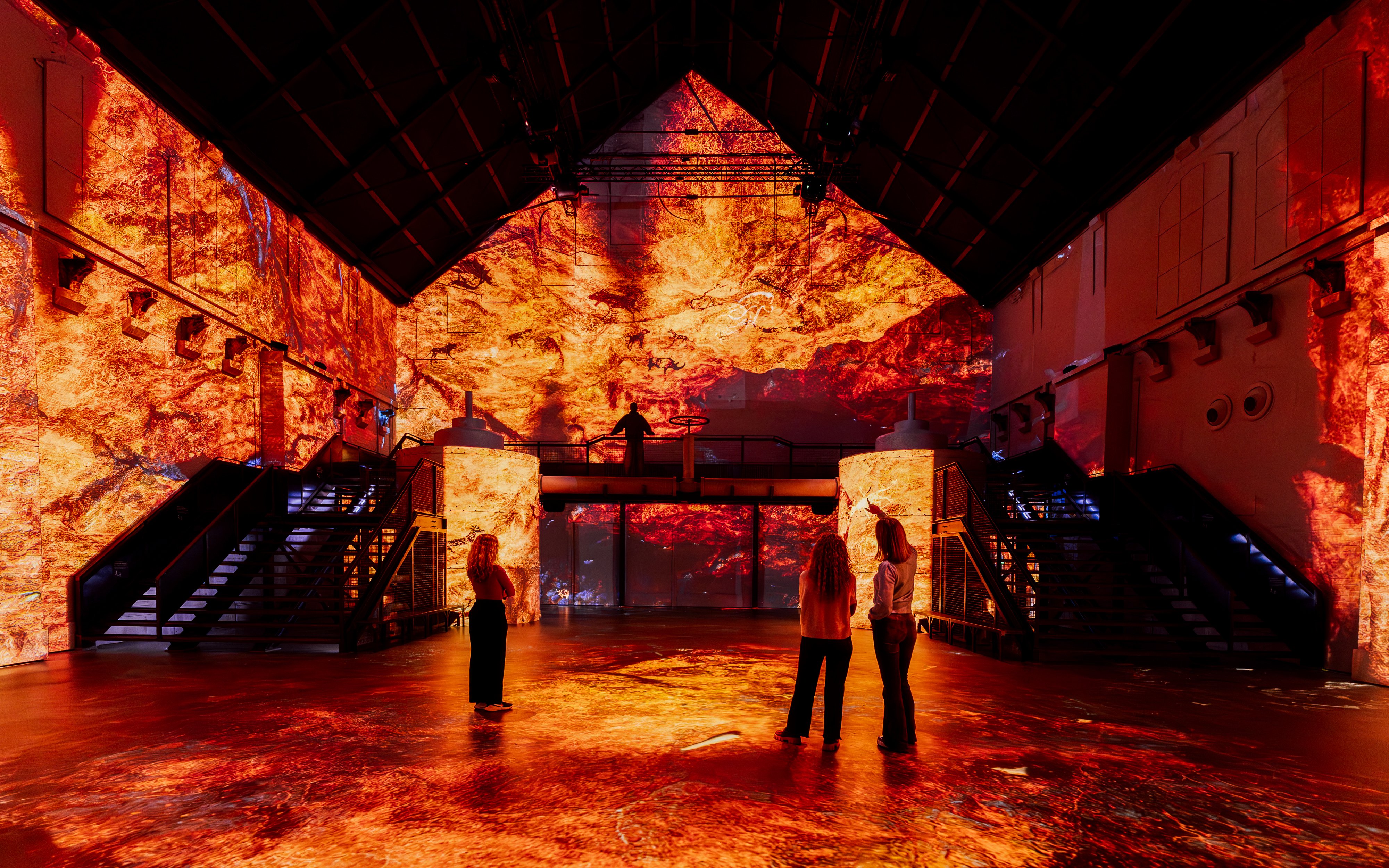 Immersive dinosaur-themed exhibit with fiery visuals at Prehistoric Planet experience.