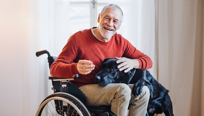 Man in wheelchair with dog, highlighting accessibility features.