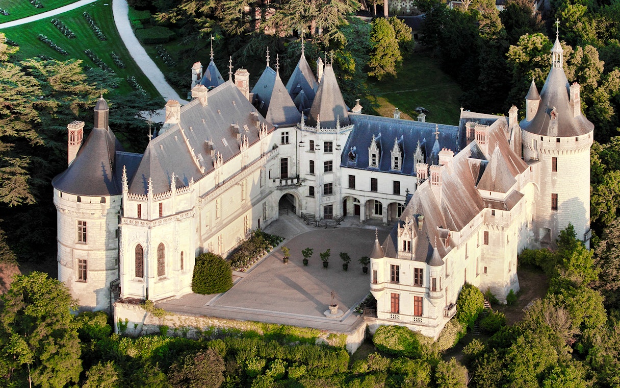 Aerial view of Chaumont-sur-Loire Castle surrounded by lush greenery.